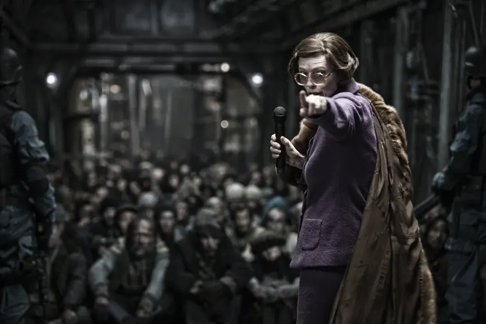 Mojo Film ; Opus Pictures/via rogerebert.com - 2013's Snowpiercer also takes place years after the apocalyptic event, which makes it easier for the film to explore societal issues alongside survival issues. Pictured here is Tilda Swinton as Mason.